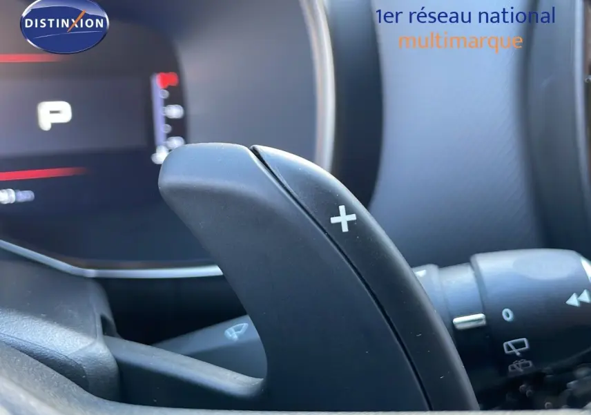 Gros plan sur la palette de changement de vitesse droite du Citroën C5 Aircross noir perla metal, intérieur moderne et tableau de bord flou.