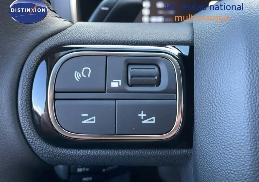 Gros plan sur les commandes au volant du Citroën C5 Aircross 2025, finition cuir noir, boutons de réglage du volume et appels.
