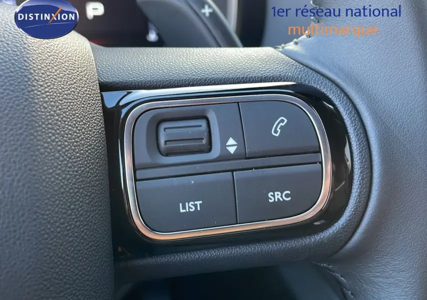 Gros plan sur les commandes au volant en cuir noir du Citroën C5 Aircross 2025, boutons LIST et SRC visibles.
