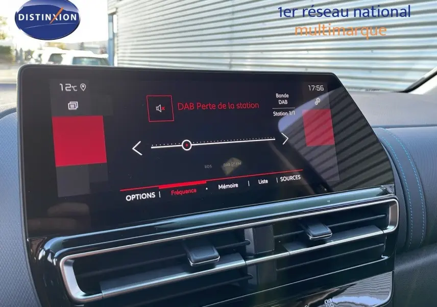 Écran tactile central du Citroën C5 Aircross 2025 affichant une interface radio DAB, avec tableau de bord noir et surpiqûres bleues.