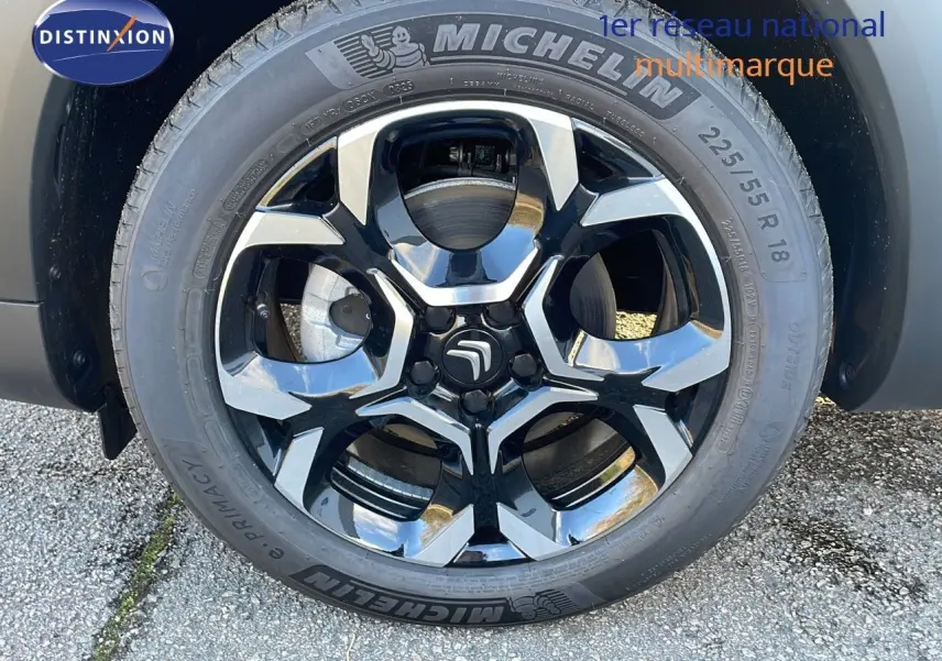 Gros plan sur la roue avant droite d'un Citroën C5 Aircross noir Perla Metal avec jante alliage bicolore et pneu Michelin.