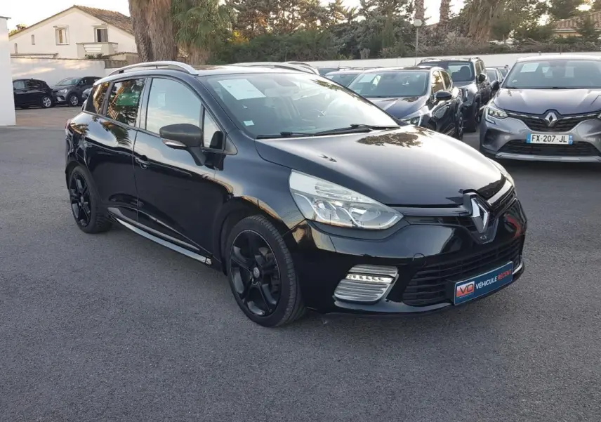 Renault Clio IV Estate noir en 3/4 avant droit, avec jantes alliage noires et feux diurnes LED visibles.