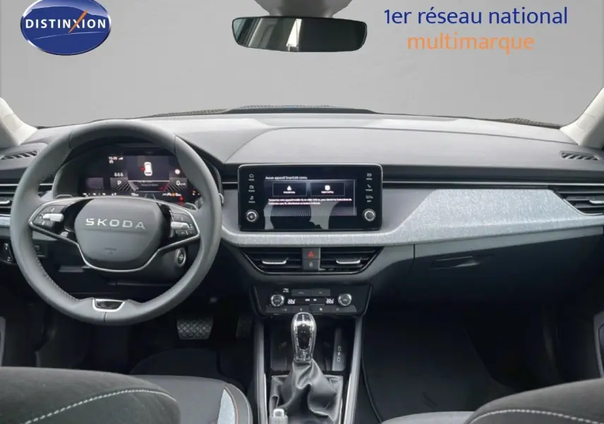 Vue intérieure frontale du tableau de bord et volant noir du Skoda Kamiq 2025 avec écran tactile central et finition grise.