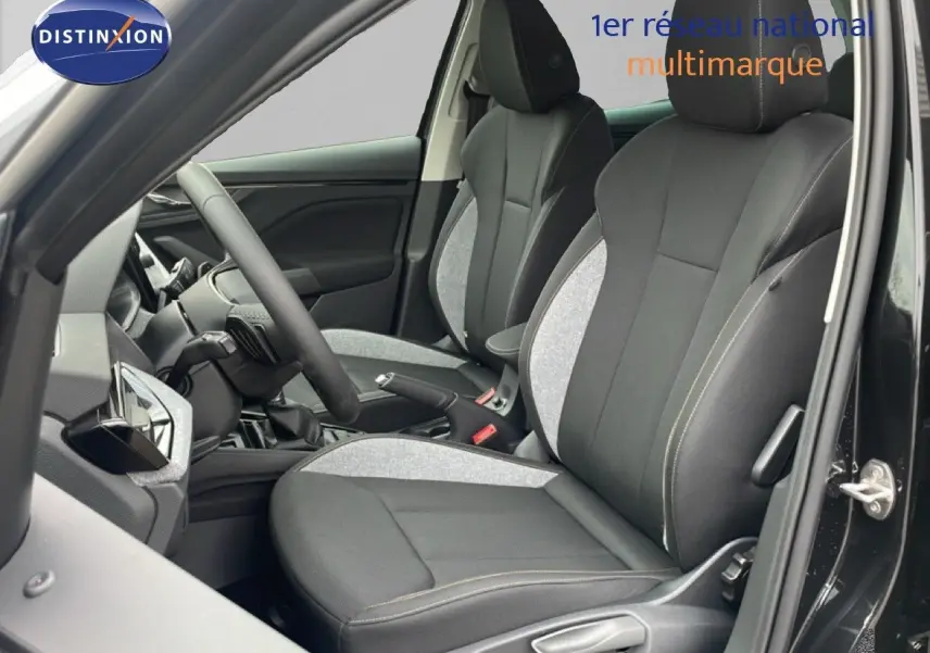 Vue intérieure côté conducteur du Skoda Kamiq 2025 noir magique métal, mettant en valeur les sièges tissu bicolores et le volant multifonction.