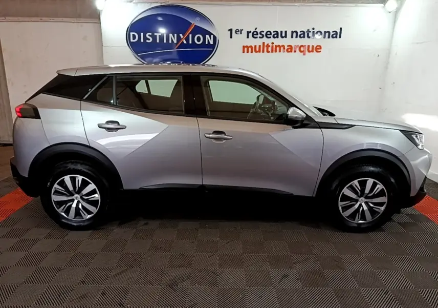 Vue de profil côté gauche d’un Peugeot 2008 gris clair, soulignant ses lignes modernes et ses jantes alliage.