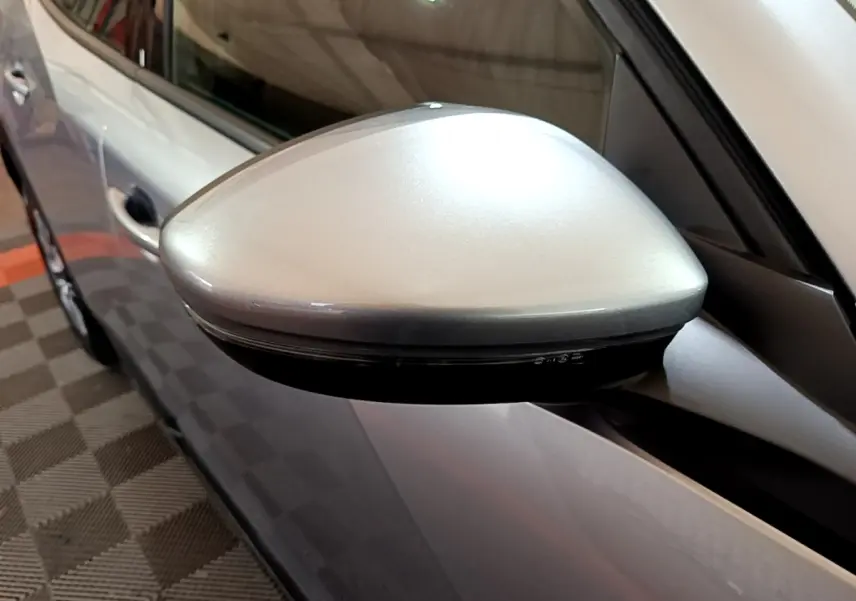 Gros plan sur le rétroviseur côté gauche gris clair du Peugeot 2008 PureTech 2021, avec carrosserie visible en arrière-plan.