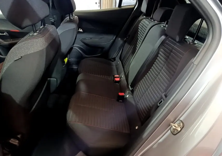 Vue intérieure côté droit des sièges arrière noirs avec surpiqûres rouges du Peugeot 2008 gris clair de 2021.