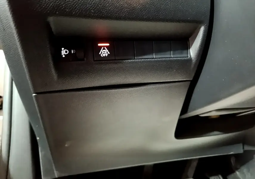 Vue rapprochée des commandes situées sous le tableau de bord côté conducteur du Peugeot 2008 gris clair 2021.