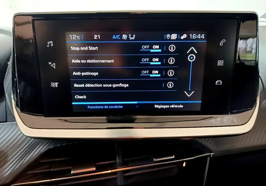Écran tactile central du tableau de bord de la Peugeot 2008 gris clair, affichant les réglages d’aide à la conduite.
