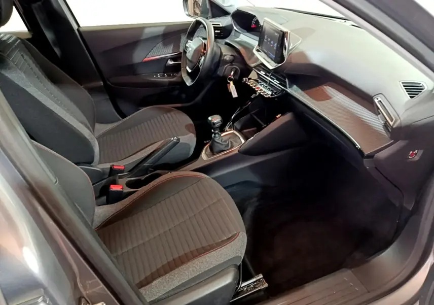 Intérieur avant droit du Peugeot 2008 gris clair 2021, avec tableau de bord moderne et écran tactile central.