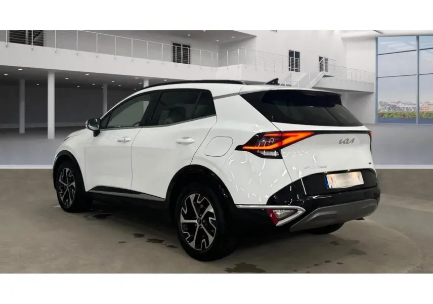 KIA SPORTAGE hybride blanc vue 3/4 arrière droit avec toit noir et jantes alliage 18 pouces en intérieur showroom.