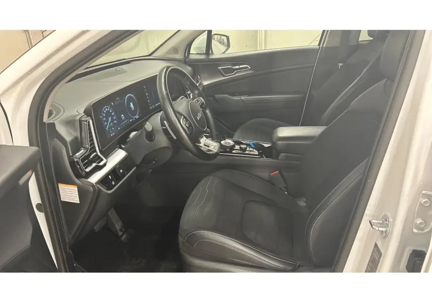 Intérieur avant droit du KIA SPORTAGE blanc 2022, volant cuir GT-line et tableau de bord digital lumineux.