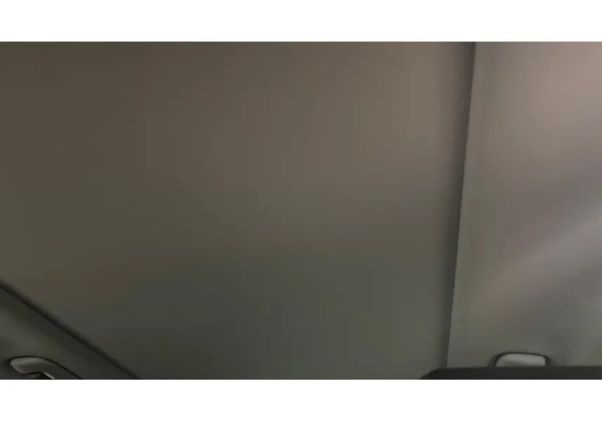 Toit intérieur gris clair du Kia Sportage hybride 2022 avec poignée de maintien visible sur le côté droit