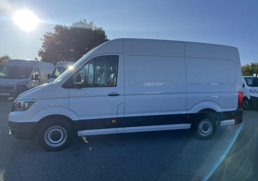 Vue latérale droite d'un Volkswagen Crafter blanc 35 L3H3 avec jantes acier et pare-chocs noirs sur parking.