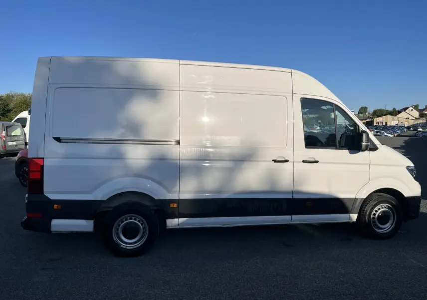 Profil droit d'un Volkswagen Crafter Fourgon blanc avec toit haut, portes latérales coulissantes et jantes acier argentées.