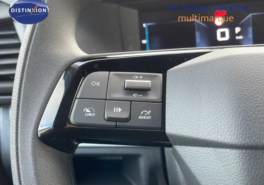 Gros plan sur les commandes au volant du Citroën Jumpy gris titane, mettant en valeur les boutons de régulateur et limiteur de vitesse.