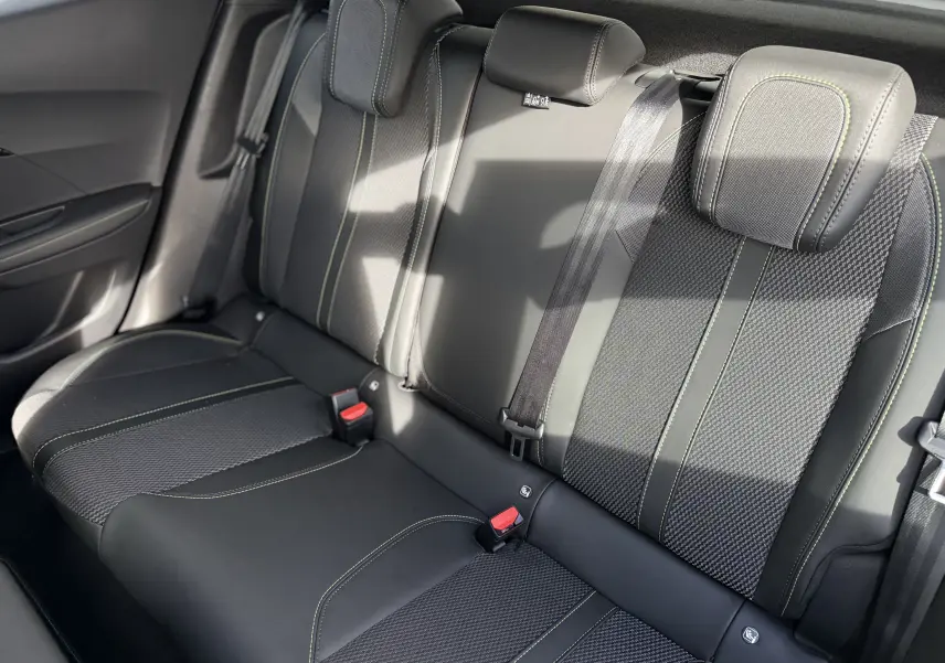 Vue intérieure des sièges arrière en cuir noir et tissu avec surpiqûres vertes du Peugeot 2008 Hybrid 145ch GT 2025.