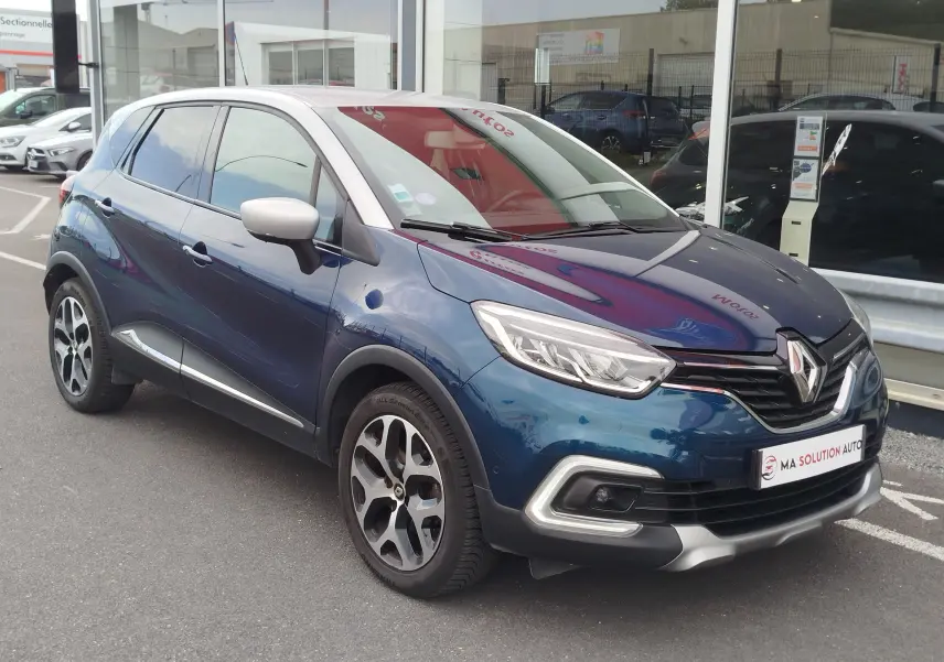 Vue 3/4 avant droite d'un Renault Captur 2018 bleu marine fumé avec toit gris platine et jantes bi-ton.