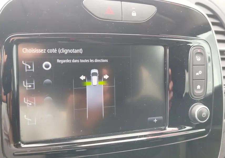 Écran tactile central du Renault Captur 2018 montrant l'aide au stationnement avec interface de choix de côté clignotant.