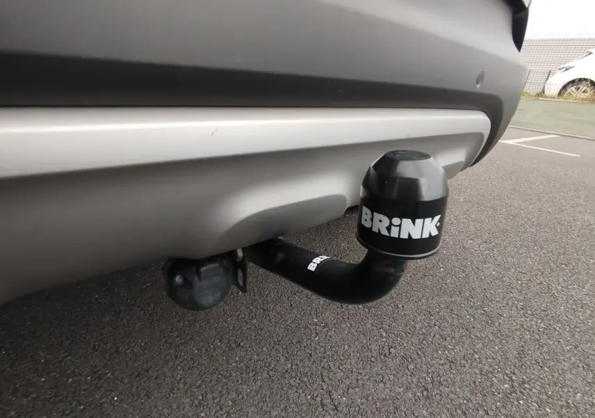 Gros plan sur l'attelage de remorque noir Brink sous le pare-chocs arrière gris platine du Renault Captur 2018.