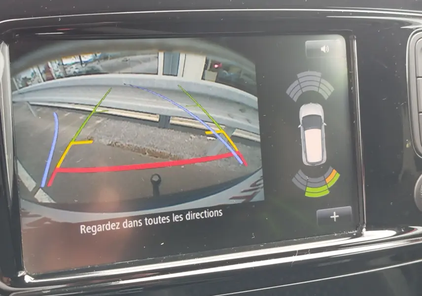 Affichage de la caméra de recul du Renault Captur bleu marine fumé, avec lignes de guidage colorées et capteurs de proximité actifs.