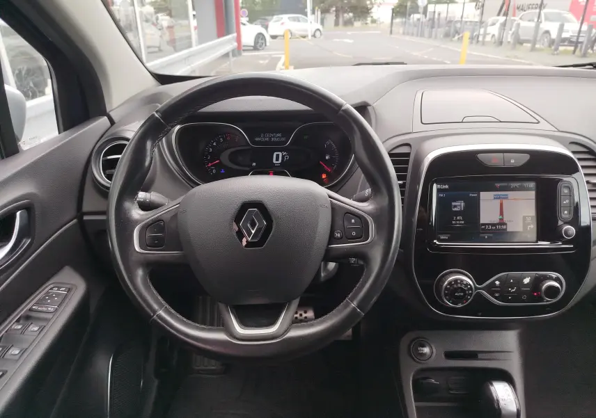 Vue intérieure centrée sur le volant et le tableau de bord du Renault Captur 2018, avec écran tactile et commandes intégrées.