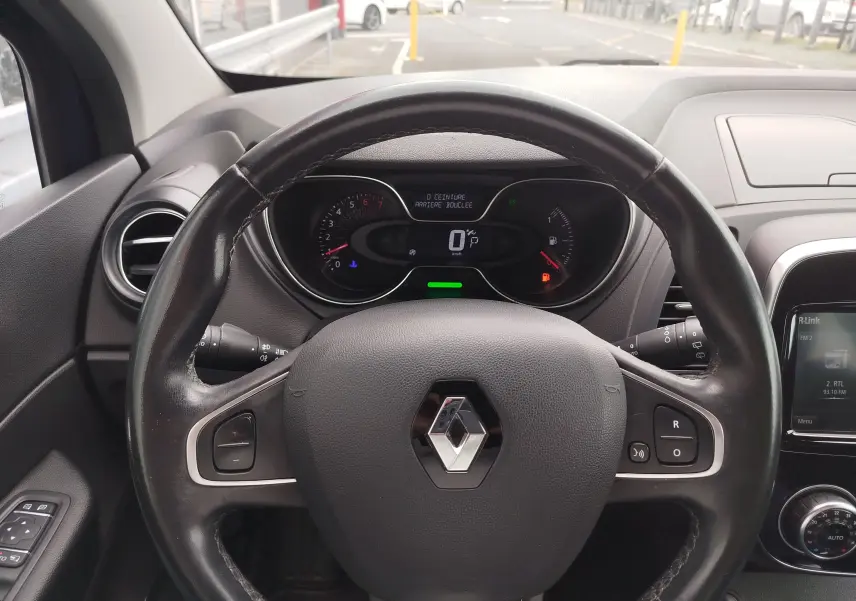 Vue intérieure centrée sur le volant noir du Renault Captur 2018, avec tableau de bord digital et commandes visibles.