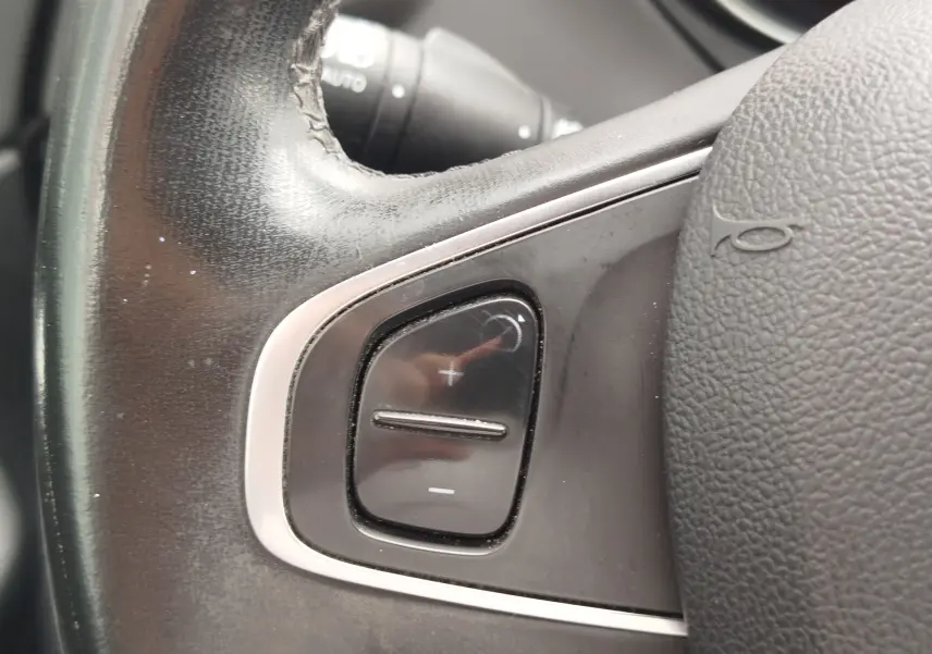 Gros plan sur les commandes de volume au volant en cuir noir du Renault Captur 2018, finition Intens.