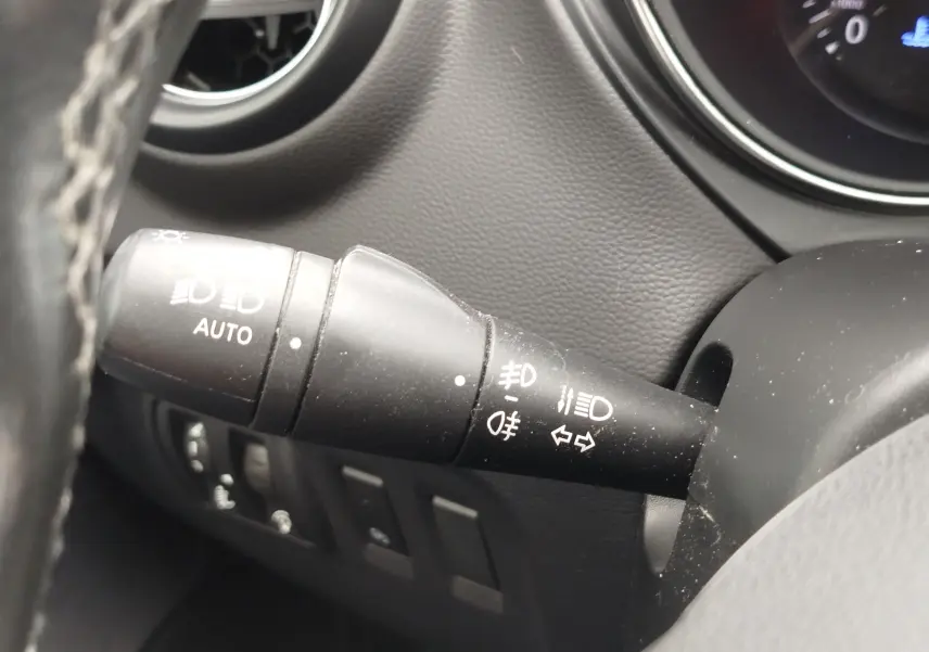 Gros plan sur la commande des phares à gauche du volant dans l’habitacle gris d’un Renault Captur 2018.