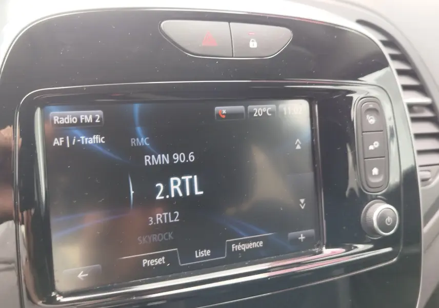 Écran tactile central du Renault Captur 2018 affichant la radio FM sur fond noir brillant avec commandes latérales.