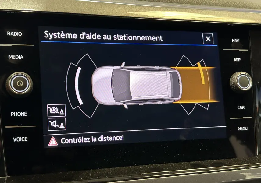 Affichage du système d'aide au stationnement du Volkswagen Taigo blanc, vue de dessus du véhicule sur l'écran tactile.