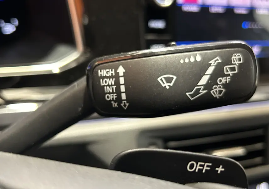 Gros plan sur la manette d'essuie-glace du Volkswagen Taigo TSI 110 DSG7 Style 2022, intérieur noir.