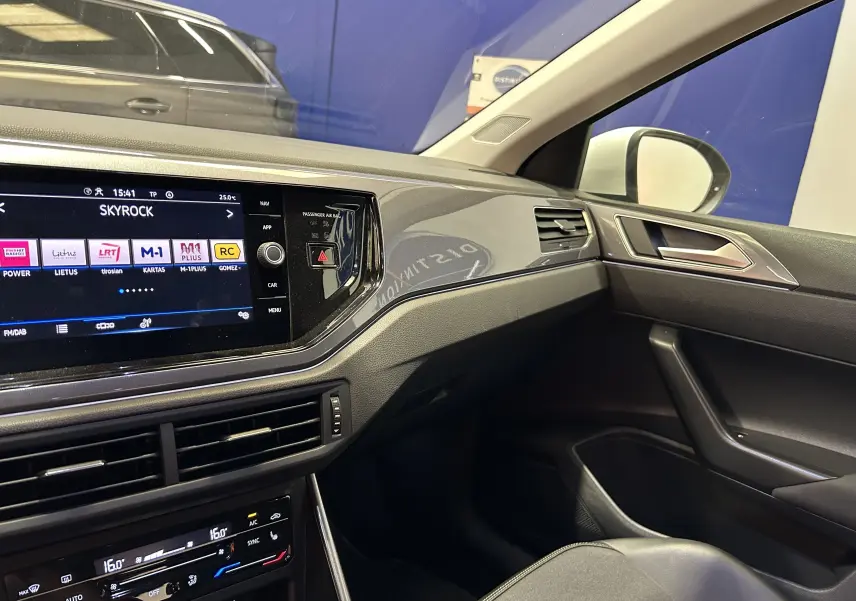 Intérieur moderne du Volkswagen Taigo blanc, vue côté passager avec écran tactile et tableau de bord noir élégant.