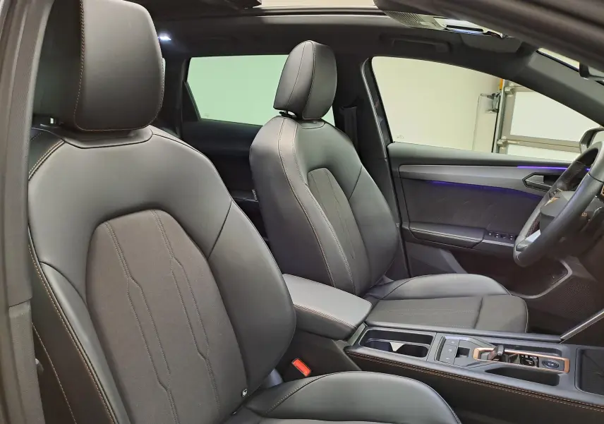 Vue intérieure côté droit de la CUPRA LEON ST 2.0 TDI 150 DSG7 avec sièges cuir noirs et toit ouvrant panoramique.