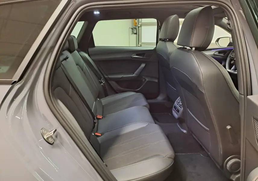 Vue intérieure côté gauche sur les sièges arrière noirs du CUPRA LEON ST gris Graphène avec toit ouvrant panoramique visible.