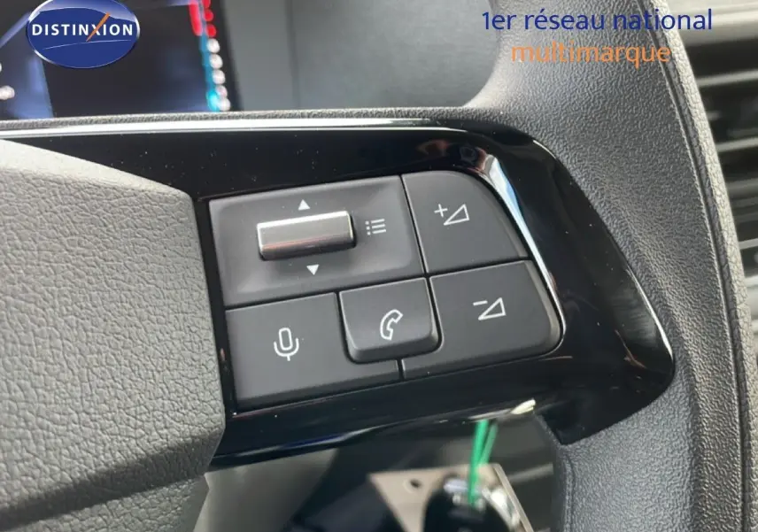 Gros plan sur les commandes au volant du Citroën Jumpy gris titane, boutons de volume et téléphone visibles.