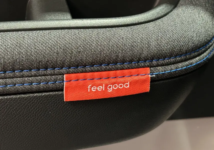 Détail de la couture bleue et étiquette rouge "feel good" sur la sellerie tissu et cuir d'une Citroën C3 2025 gris Artense.