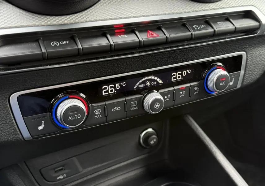Gros plan sur la console de climatisation automatique bi-zone de l'Audi Q2 35 TFSI S-Line 2023, avec commandes rotatives et affichage digital.