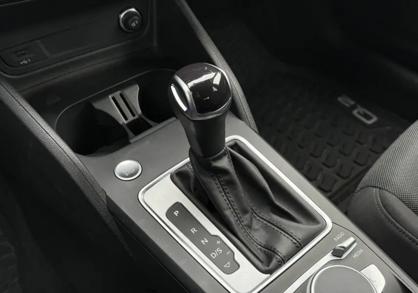 Le levier de vitesses automatique de l'Audi Q2 35 TFSI S-Line en gros plan, intérieur noir.