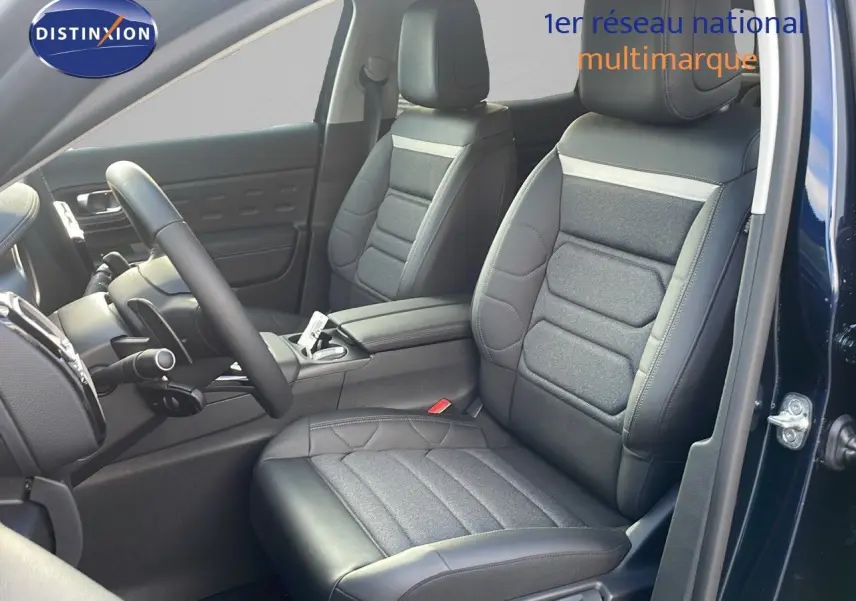 Intérieur avant du Citroën C5 Aircross bleu Eclipse Metal, sièges en cuir noir et tissu gris, volant visible côté gauche.