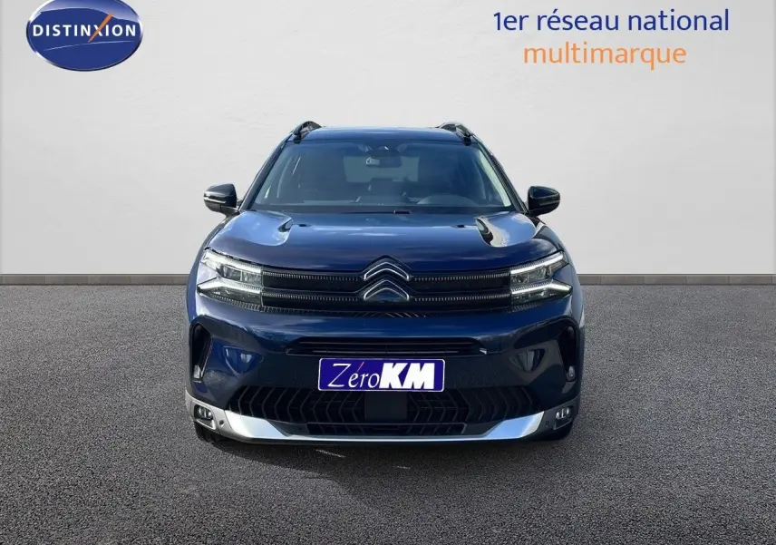 Vue frontale d'un Citroën C5 Aircross 2025 bleu Eclipse Metal avec calandre distinctive et feux LED allumés.