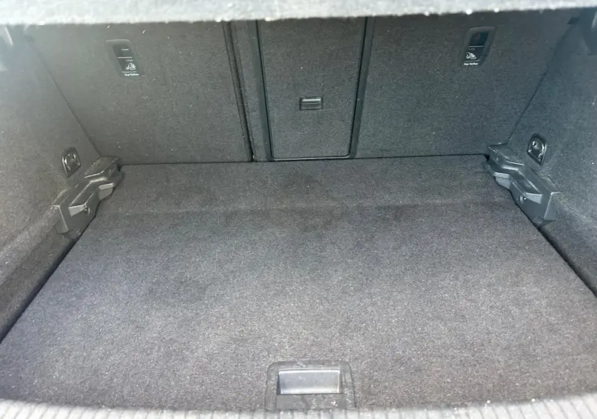 Coffre spacieux et propre de la Volkswagen Golf 1.5 TSI noir, vue intérieure depuis l'ouverture arrière.