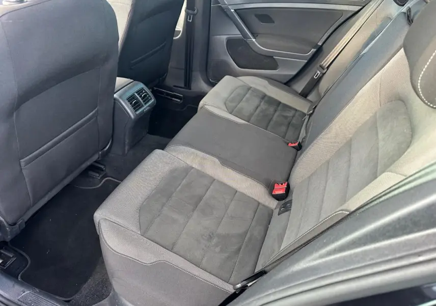 Vue intérieure côté droit des sièges arrière en tissu gris et noir d'une Volkswagen Golf 1.5 TSI noire de 2018.