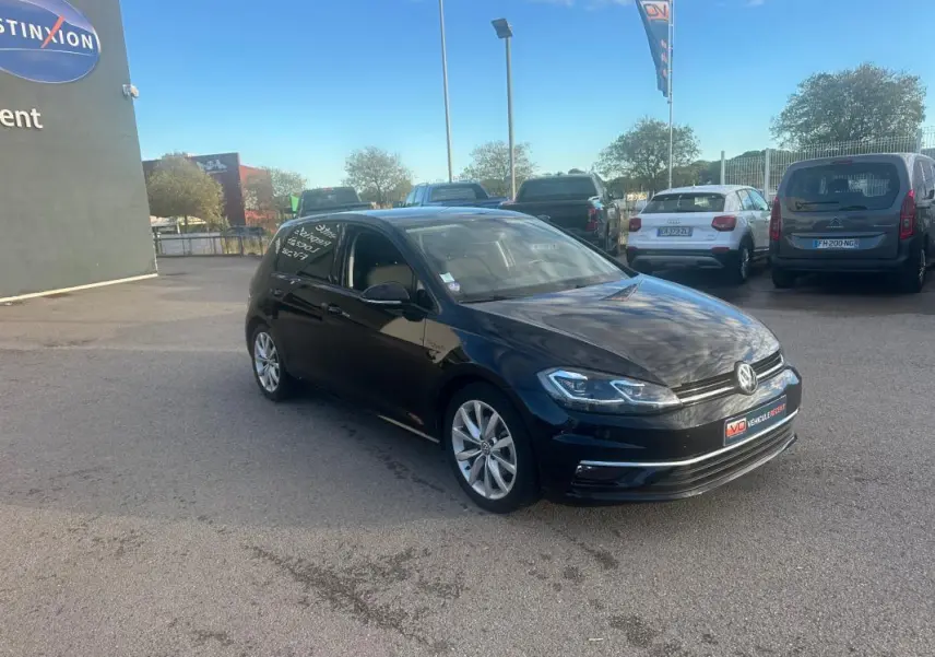 Volkswagen Golf noire vue en 3/4 avant droit, avec jantes alliage 17 pouces et phares LED visibles.