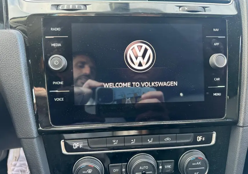 Écran tactile central allumé avec logo Volkswagen dans l'habitacle noir d'une Golf 1.5 TSI 2018.