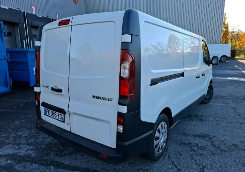 Renault Trafic blanc vu en 3/4 arrière droit, fourgon utilitaire avec portes arrière fermées et jantes acier.