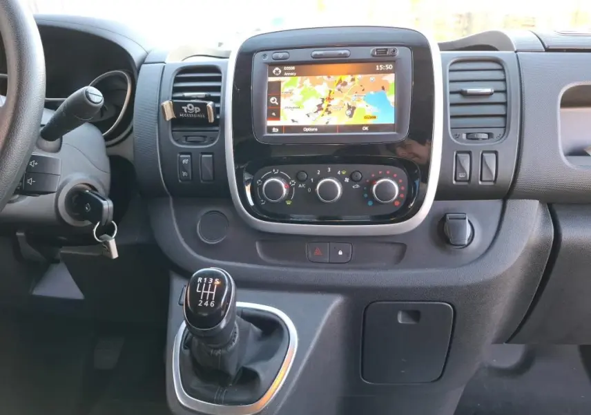 Vue rapprochée du tableau de bord du Renault Trafic Fourgon blanc 2019, avec écran GPS et levier de vitesses manuel.