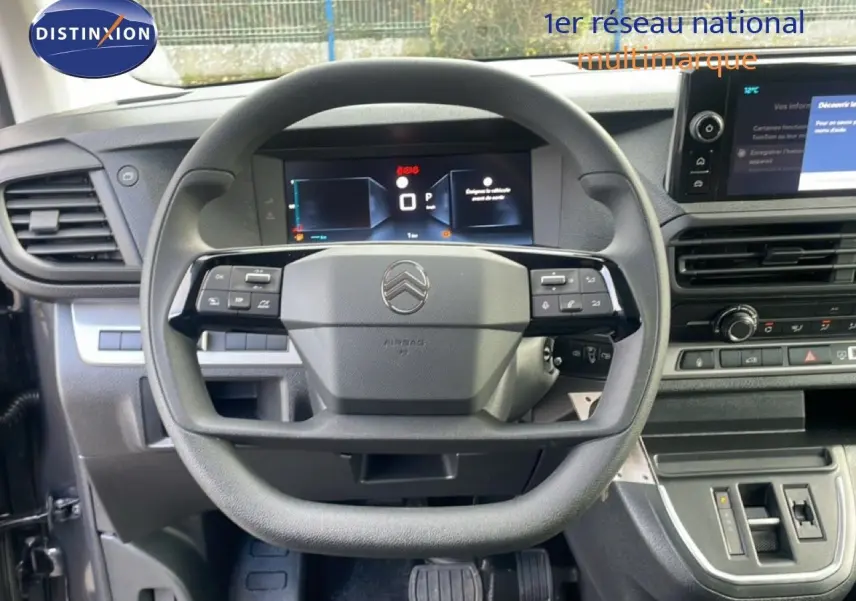Vue intérieure centrée sur le volant multifonction et le tableau de bord numérique du Citroën Jumpy gris titane.