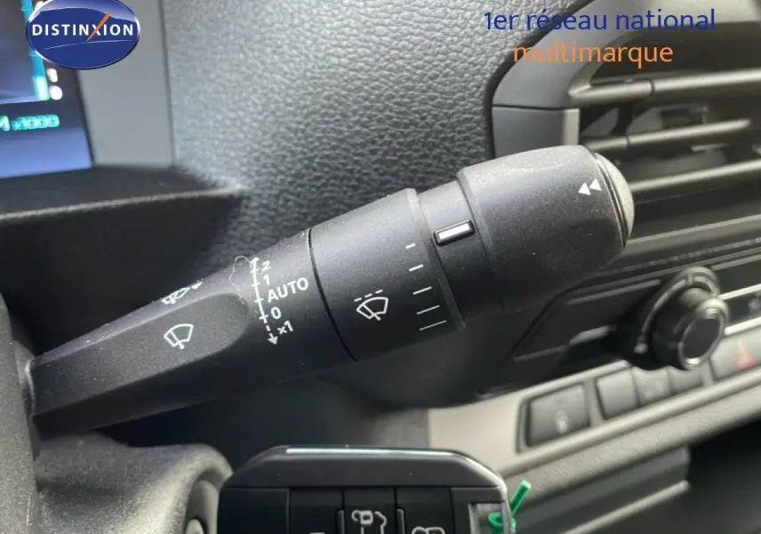 Gros plan sur la commande d’essuie-glace à gauche du volant dans l’habitacle gris d’un Citroën Jumpy gris titane.