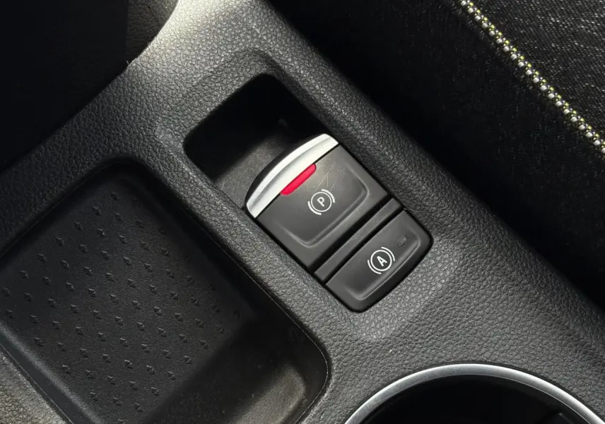 Gros plan sur la console centrale noire du Renault Captur 2025, montrant le frein de parking électrique et l'auto-hold.